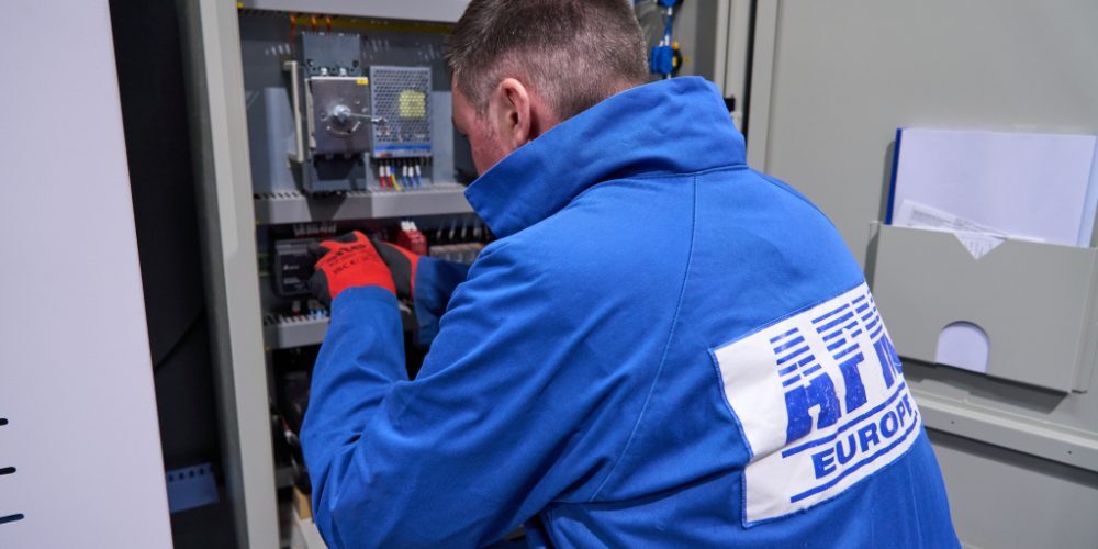 An engineer at AFM's Servicing team working on an electrical box